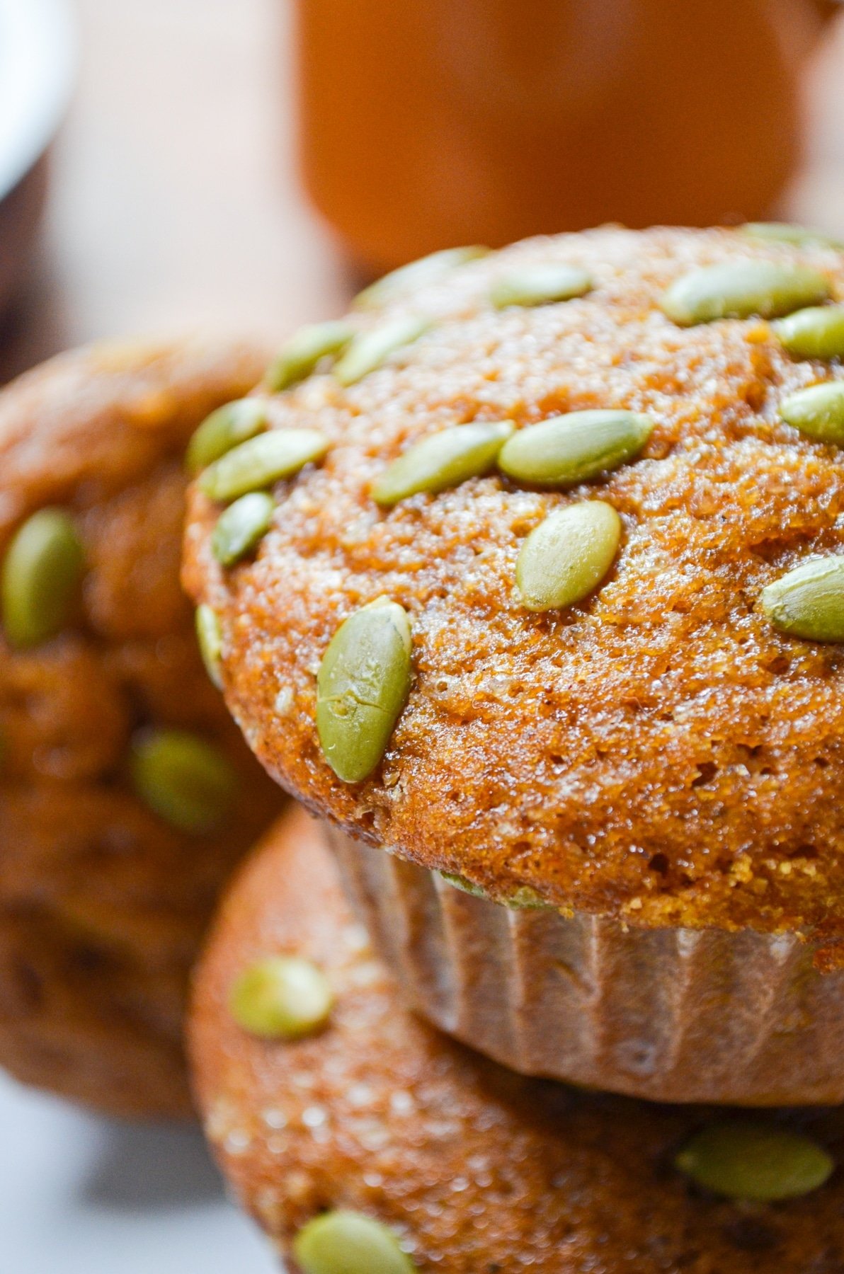 A stack of pumpkin muffins, topped with pepitas.