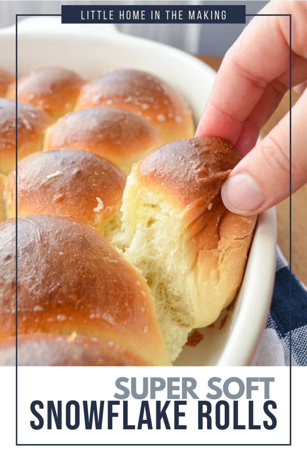 A soft dinner roll being pulled from a baking dish.