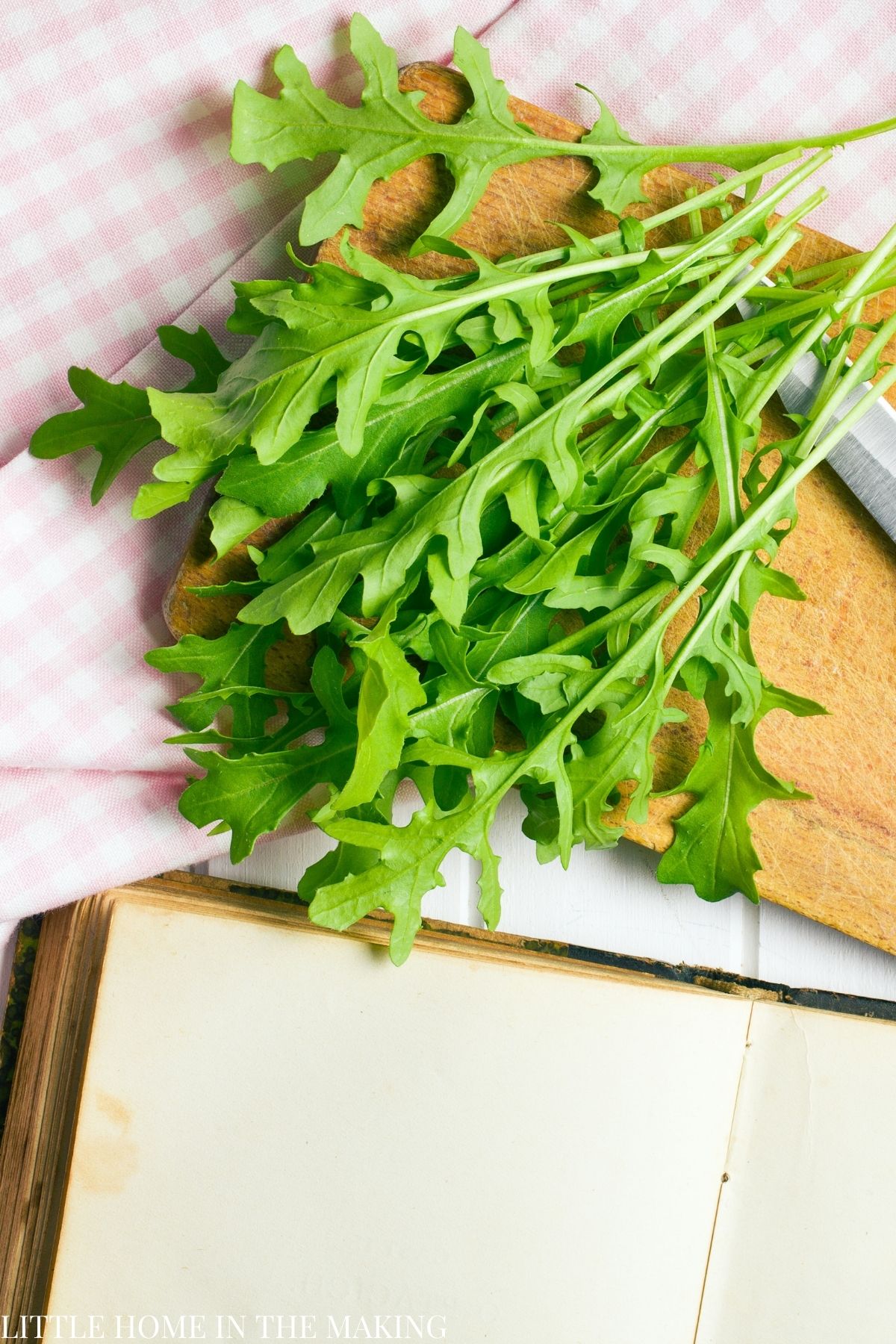 A bunch of arugula on a cutting board.