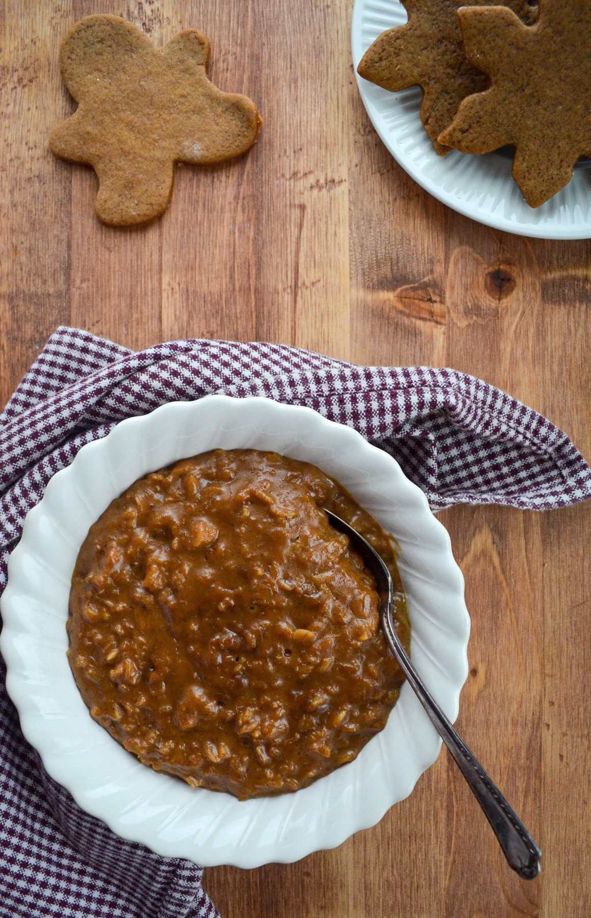 A bowl of oatmeal, with gingerbread cookies on the side.