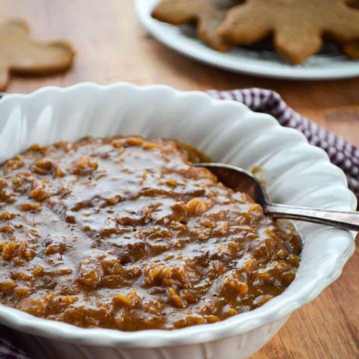 A bowl of homemade porridge, with a stack of cookies in the background.