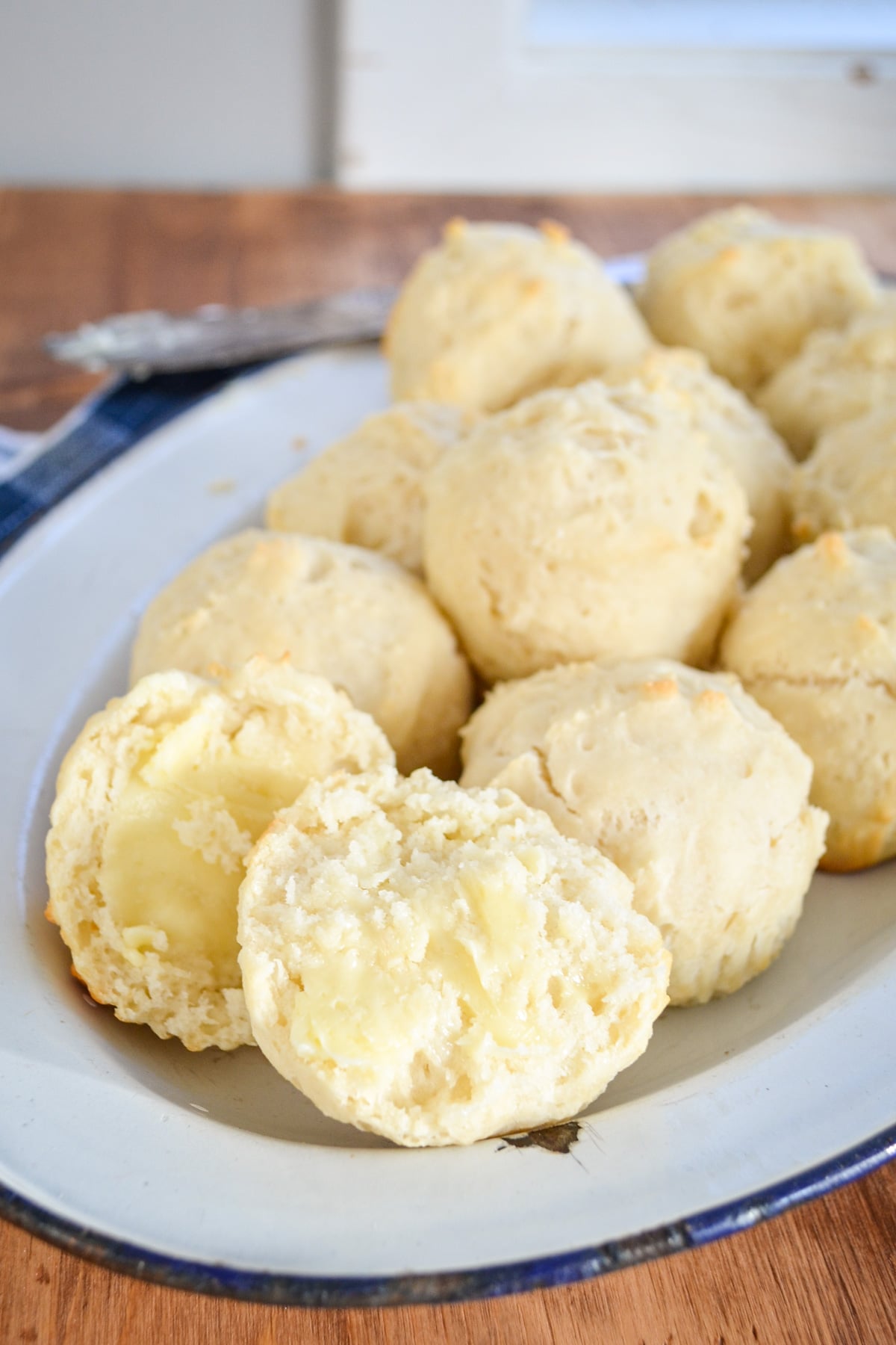 A plate of dinner rolls, resting on a cloth napkin.