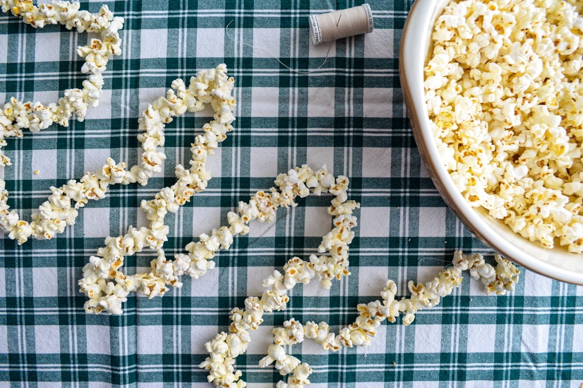 A strand of popcorn garland laying on a table cloth.