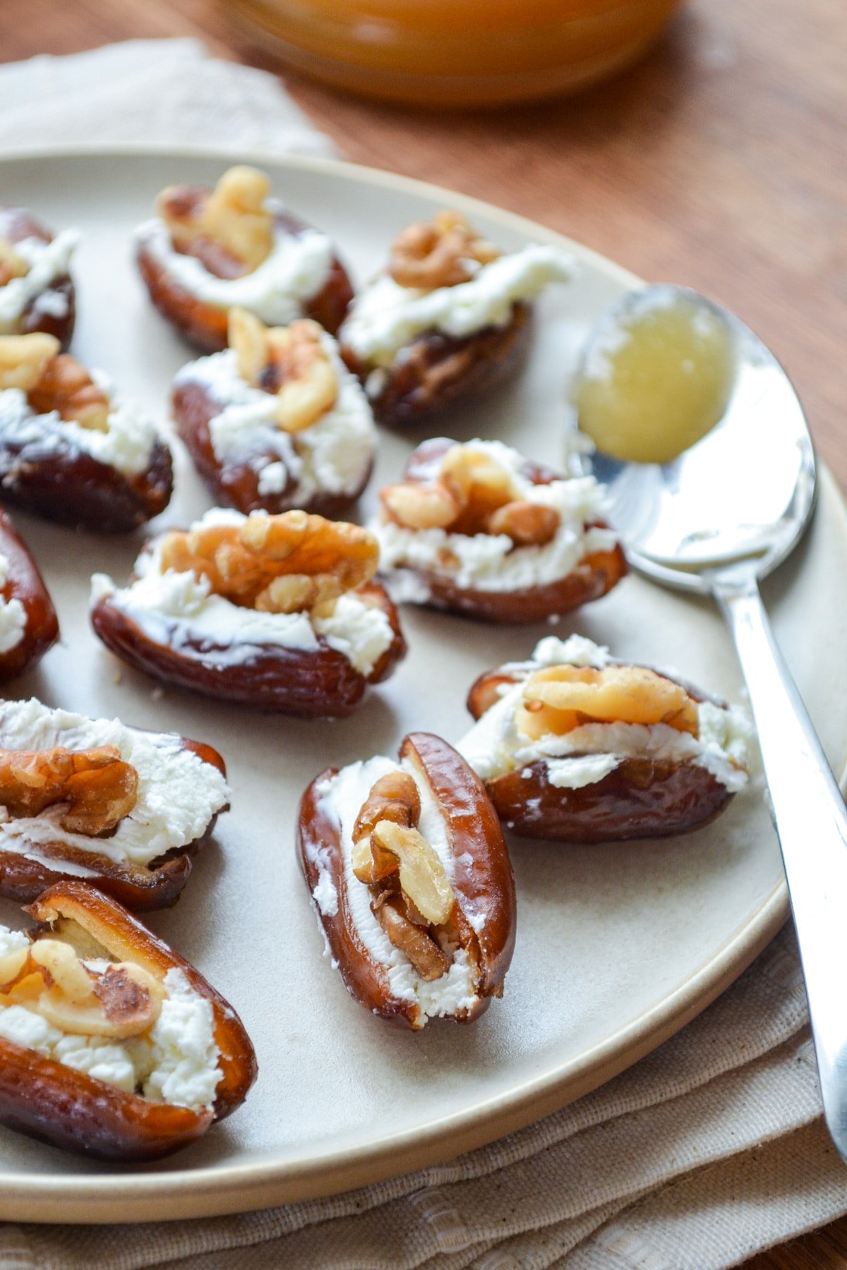 A plate full of dates stuffed with goat cheese and walnuts