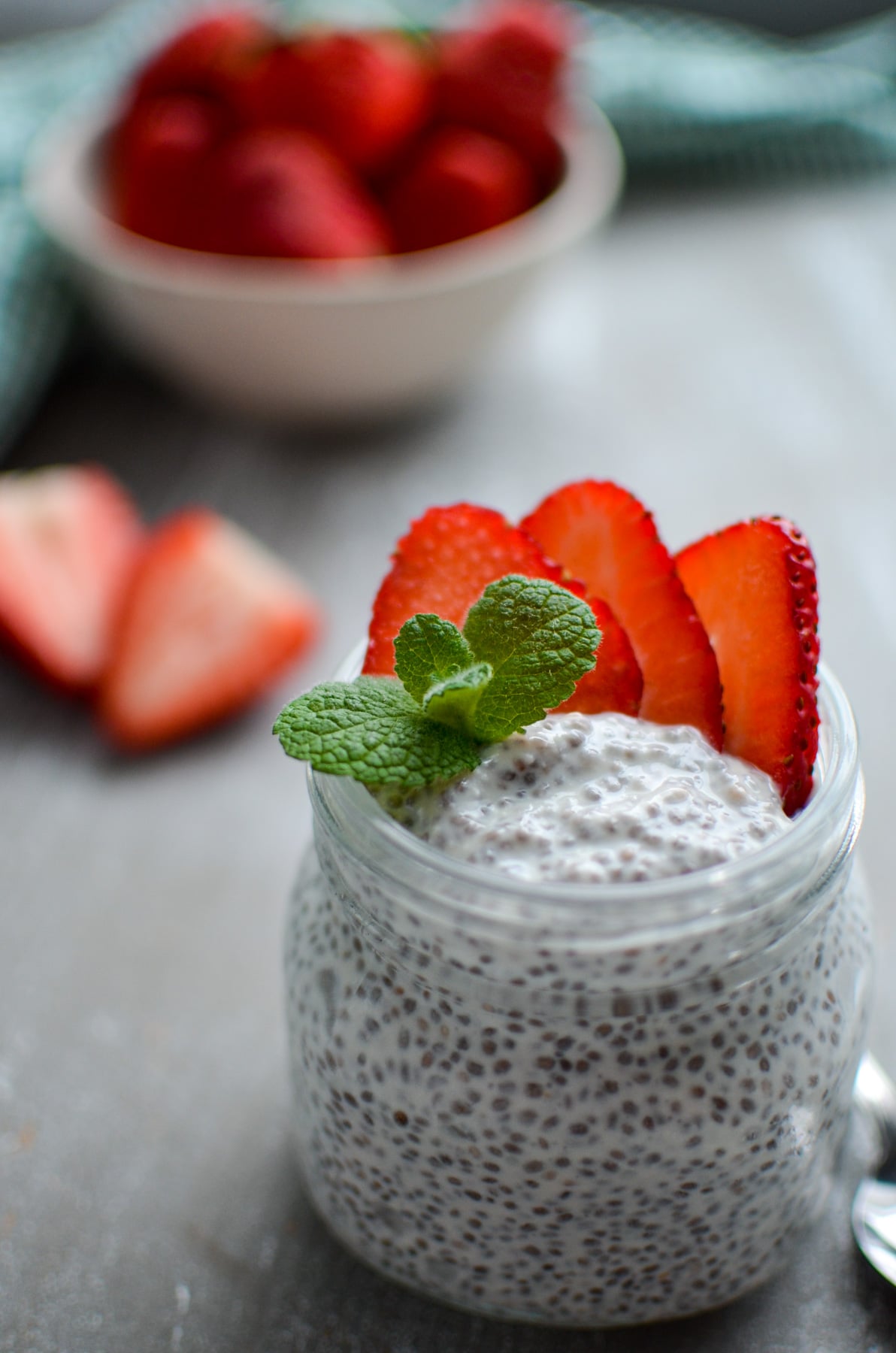 A jar of chia pudding, garnished with strawberry slices
