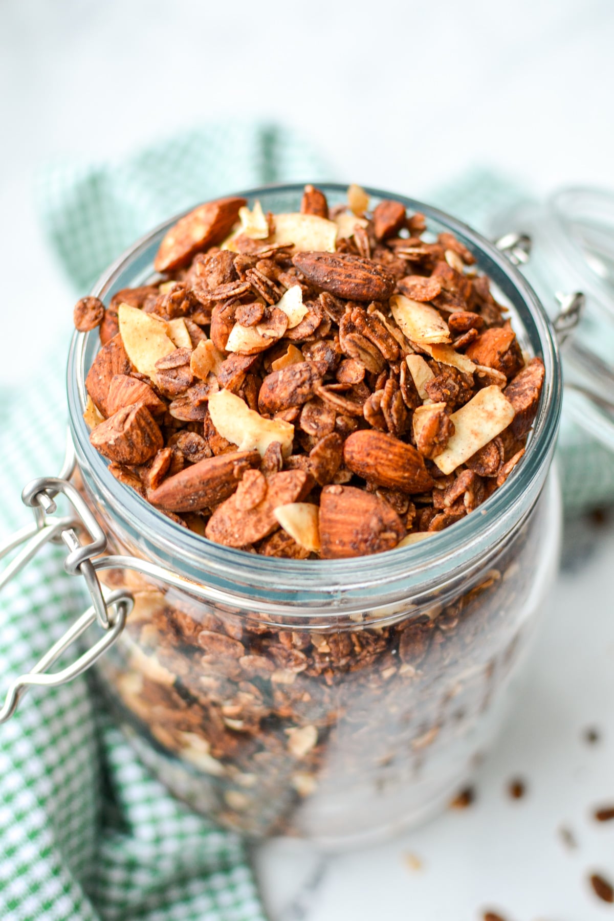 A jar of granola on a green gingham napkin.