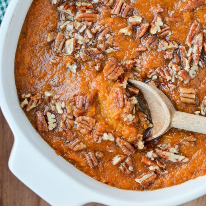 A baking dish of healthy sweet potato casserole with a pecan topping.