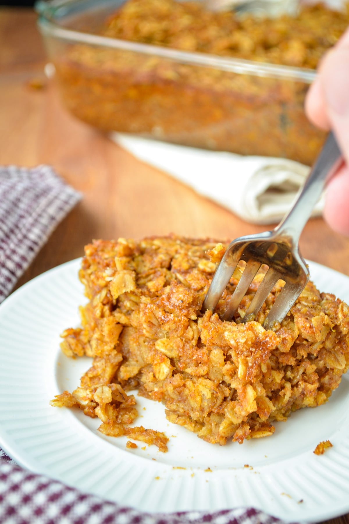 A square of pumpkin baked oatmeal with a fork sinking into it.