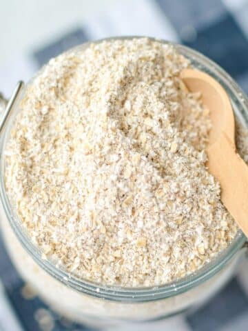 An overhead shot of a glass container with homemade sprouted out flour inside of it.