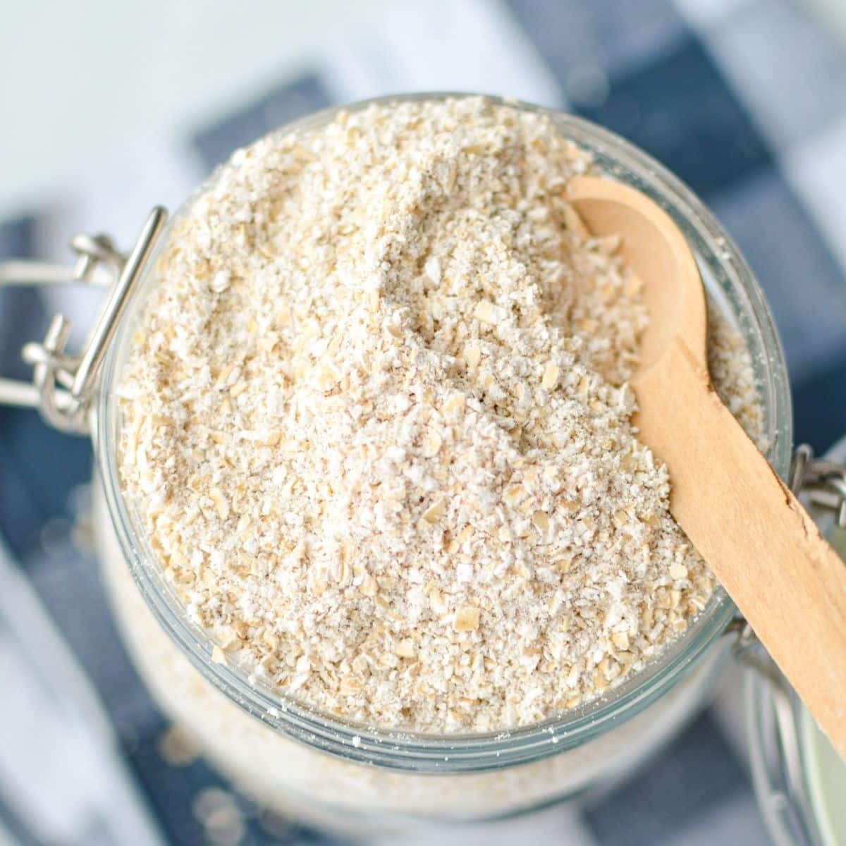 An overhead shot of a glass container with homemade sprouted out flour inside of it.