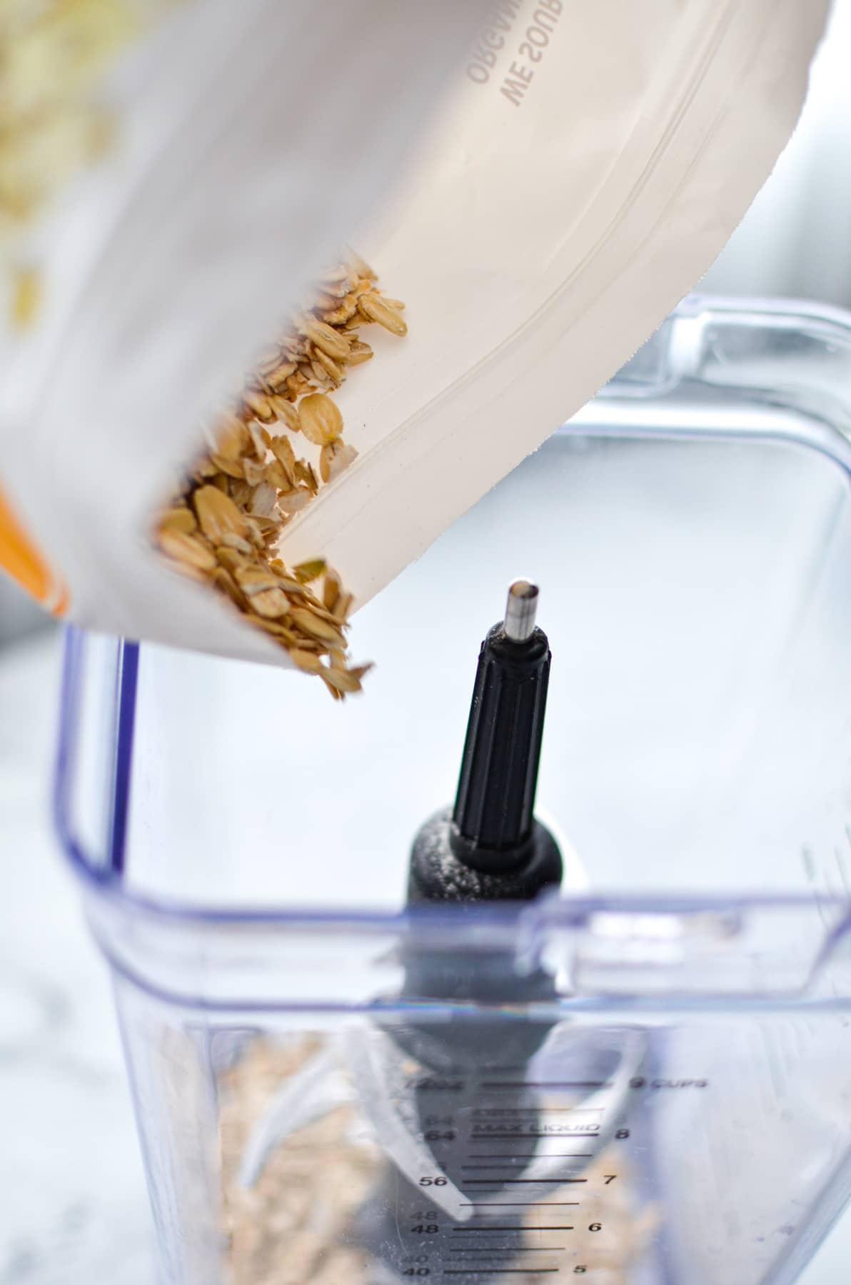 adding sprouted oats to a blender to make sprouted oat flour