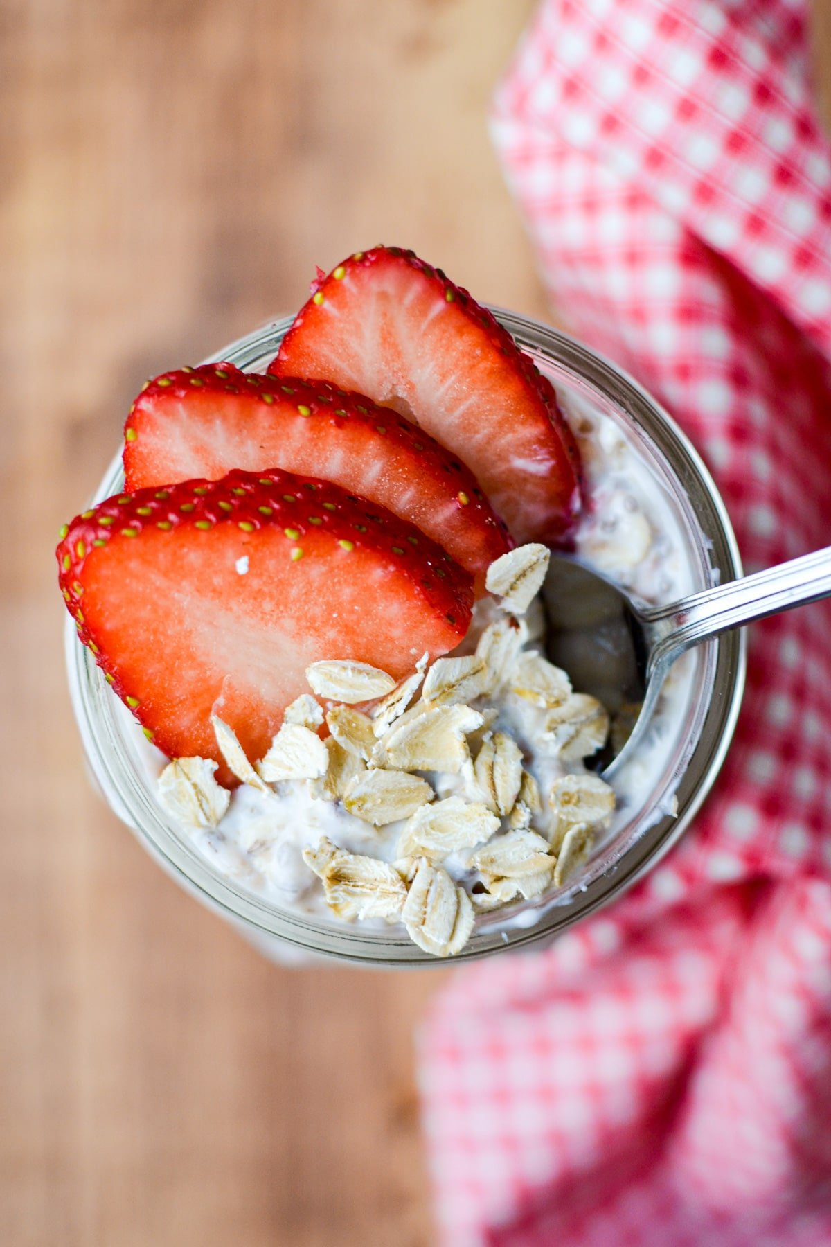 A jar of overnight oats garnished with strawberry