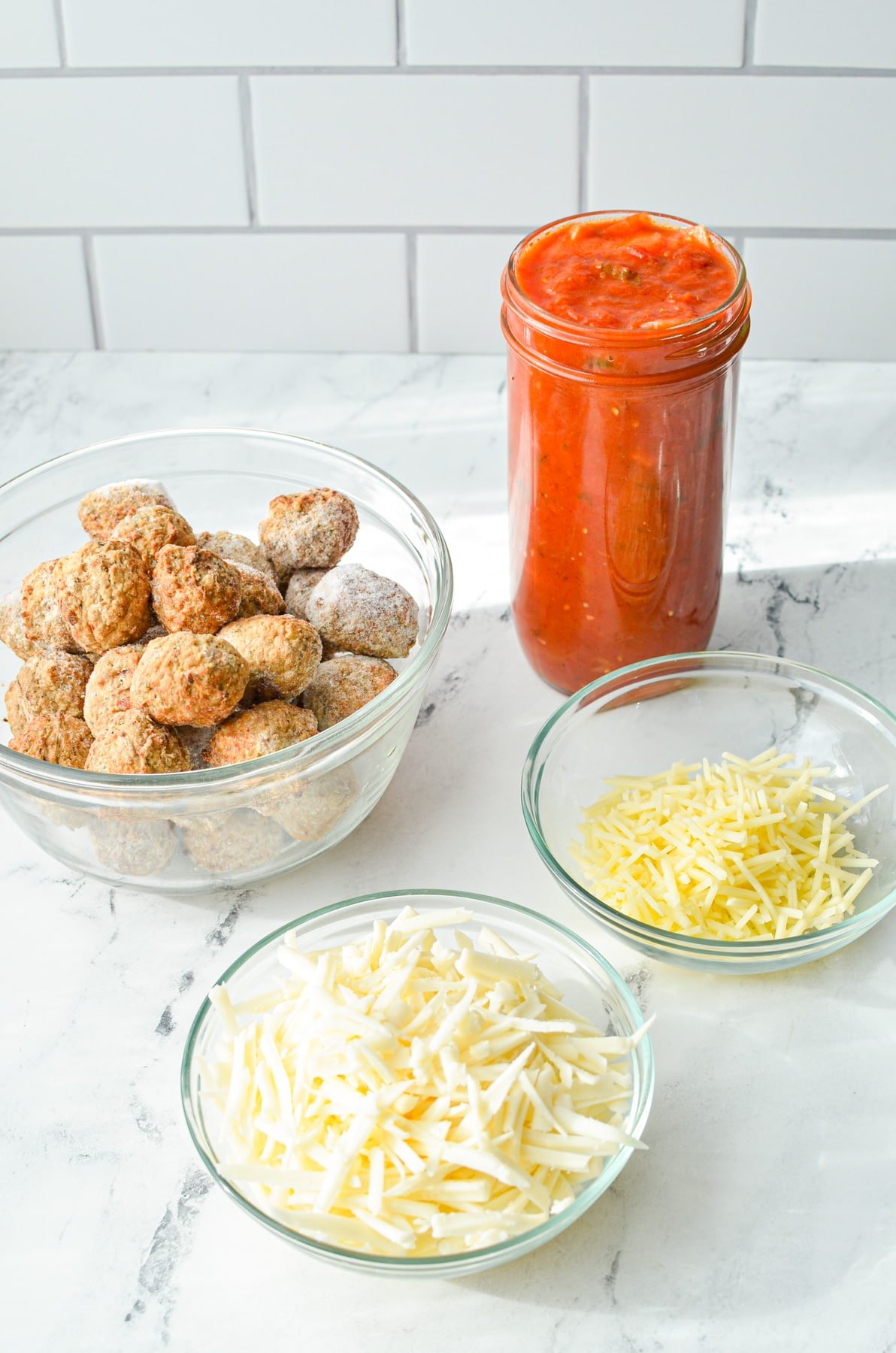 The ingredients needed to make a meatball parmesan bake