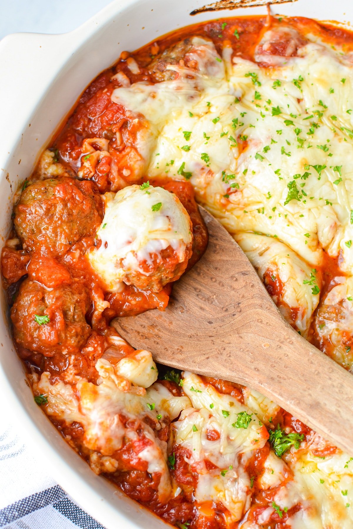 A baking dish filled with meatballs covered in marinara and topped with cheese.