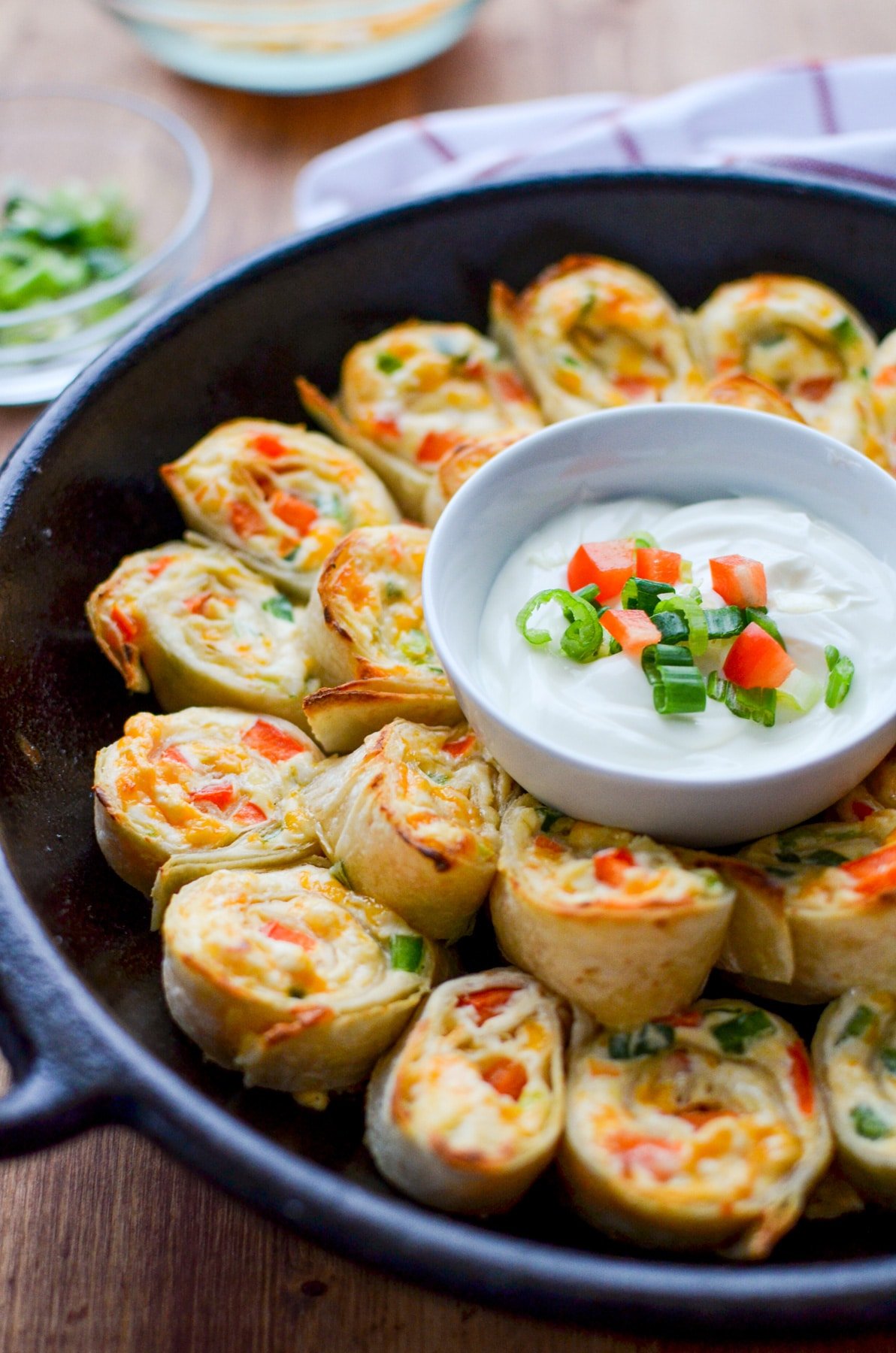 A cast iron skillet filled with jalapeno and cream cheese stuffed pinwheels.