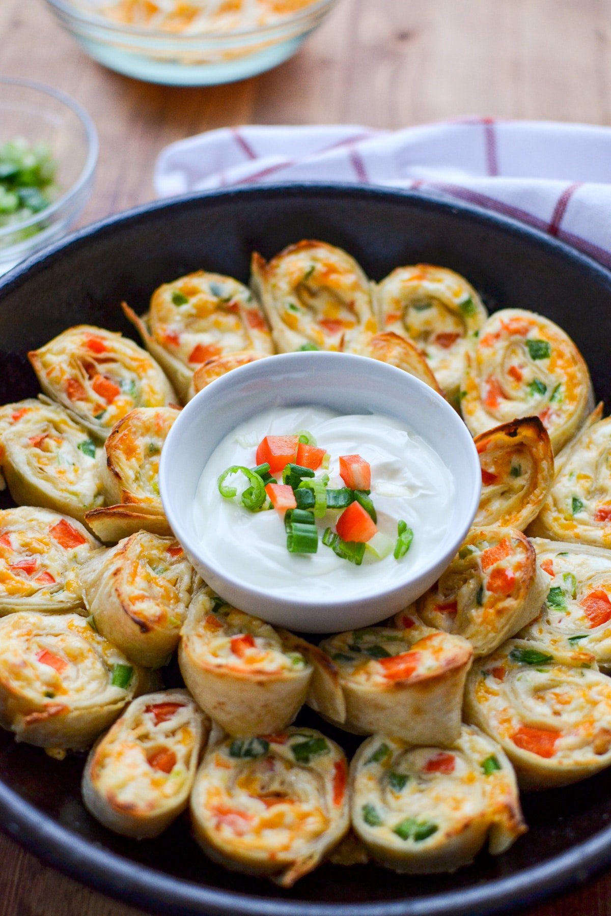 A cast iron pan full of jalapeno and cream cheese pinwheels