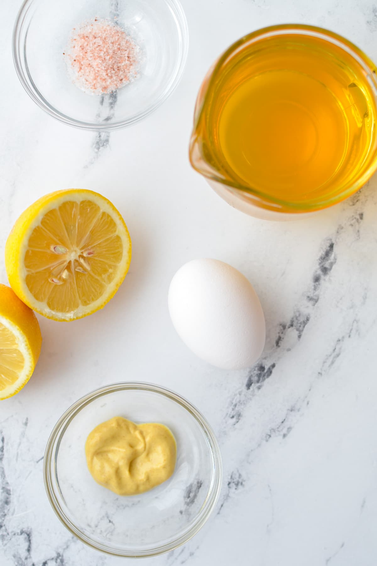 The ingredients needed to make avocado oil mayonnaise, including egg, lemon, and dijon.