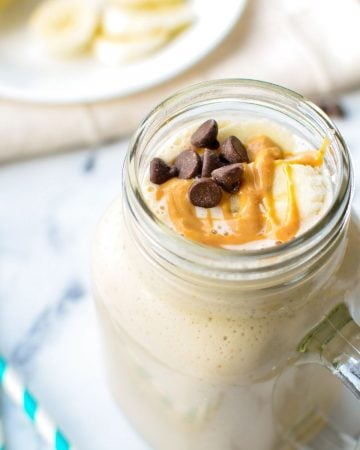 A kefir smoothie with banana and peanut butter, drizzled with peanut butter and a few chocolate chips sprinkled on top.