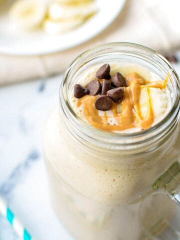 A kefir smoothie with banana and peanut butter, drizzled with peanut butter and a few chocolate chips sprinkled on top.