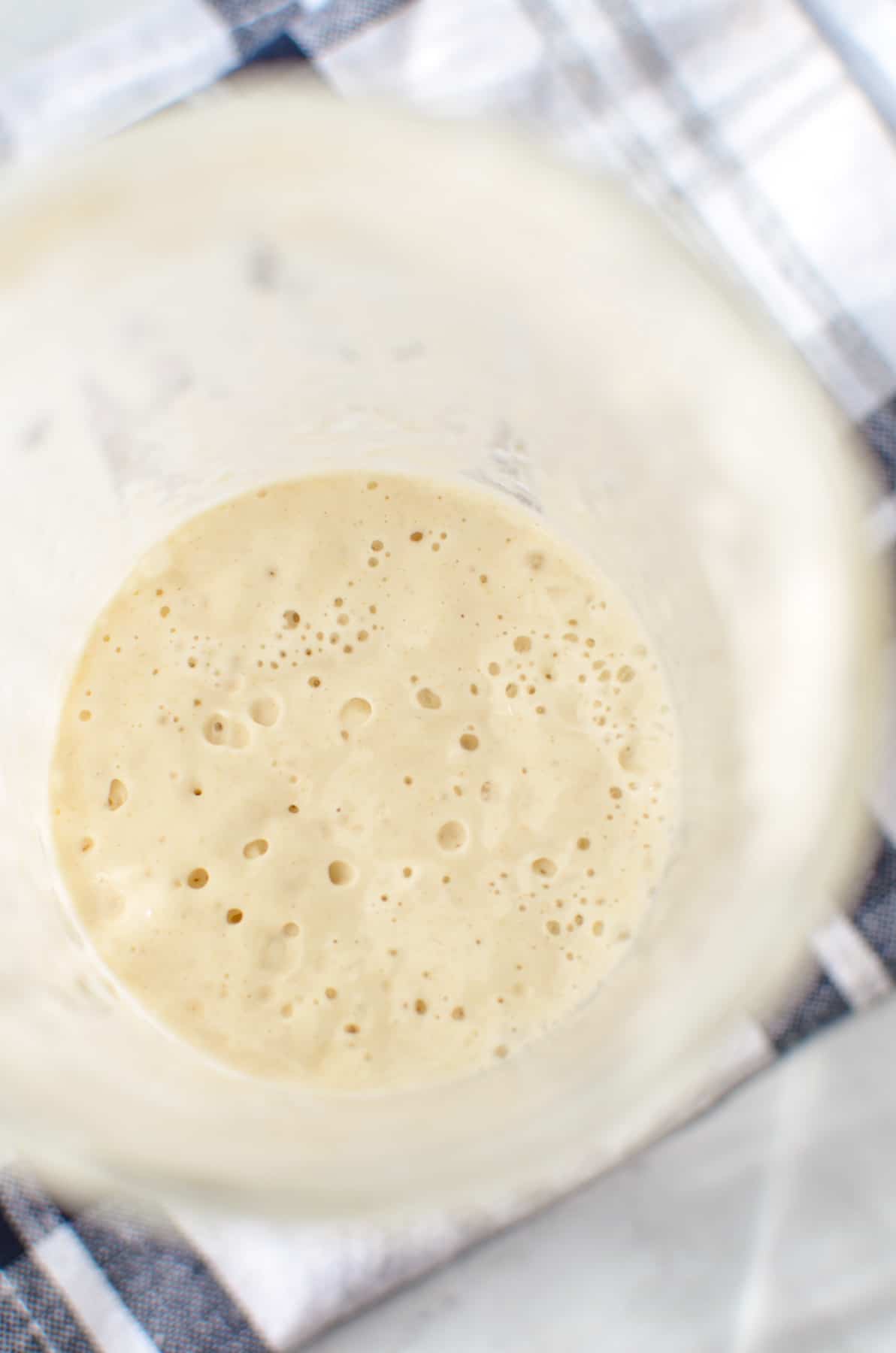 An active starter inside of a tall glass mason jar.