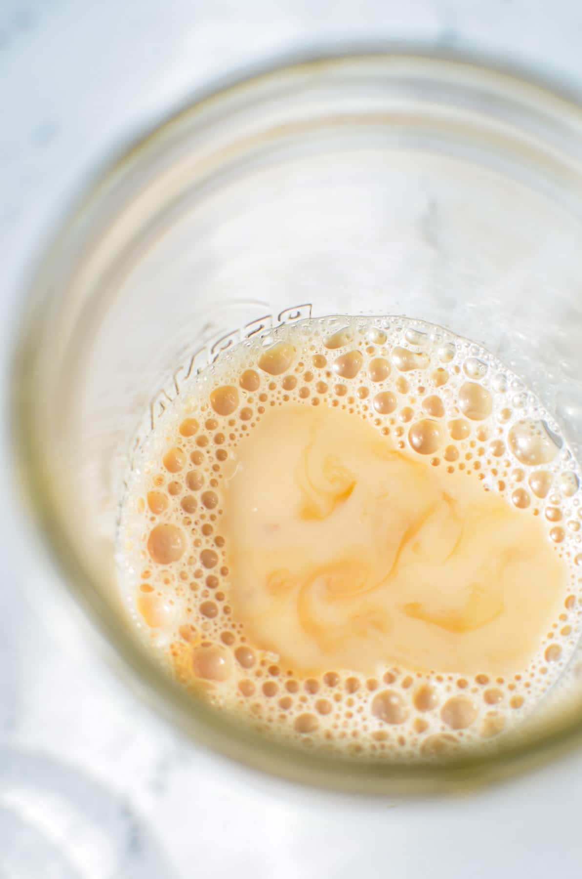 A jar of milk and tea, with honey and vanilla extract added.