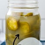 A jar of fermented jalapenos, with the text overlay that reads: how to ferment jalapenos. Preserve your harvest.