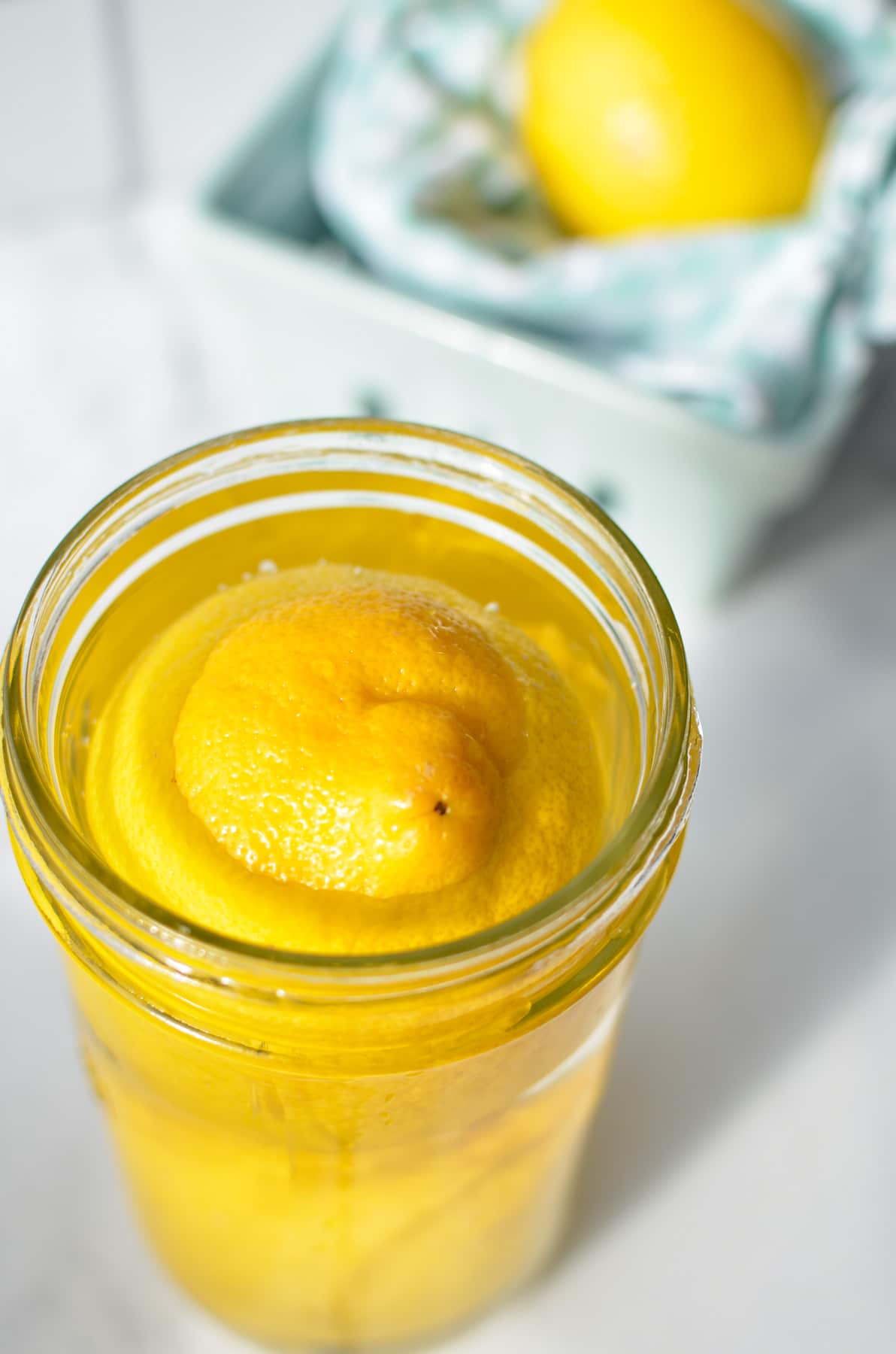 A jar of lemons, filled with water.