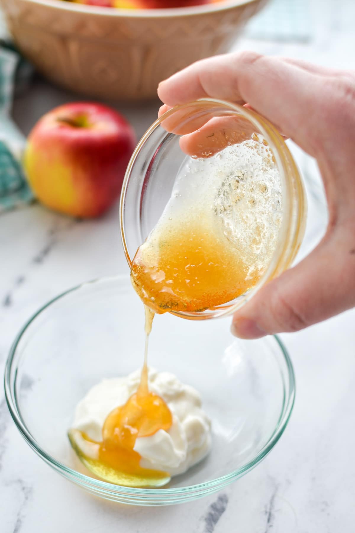 Honey being poured into a small bowl of greek yogurt.