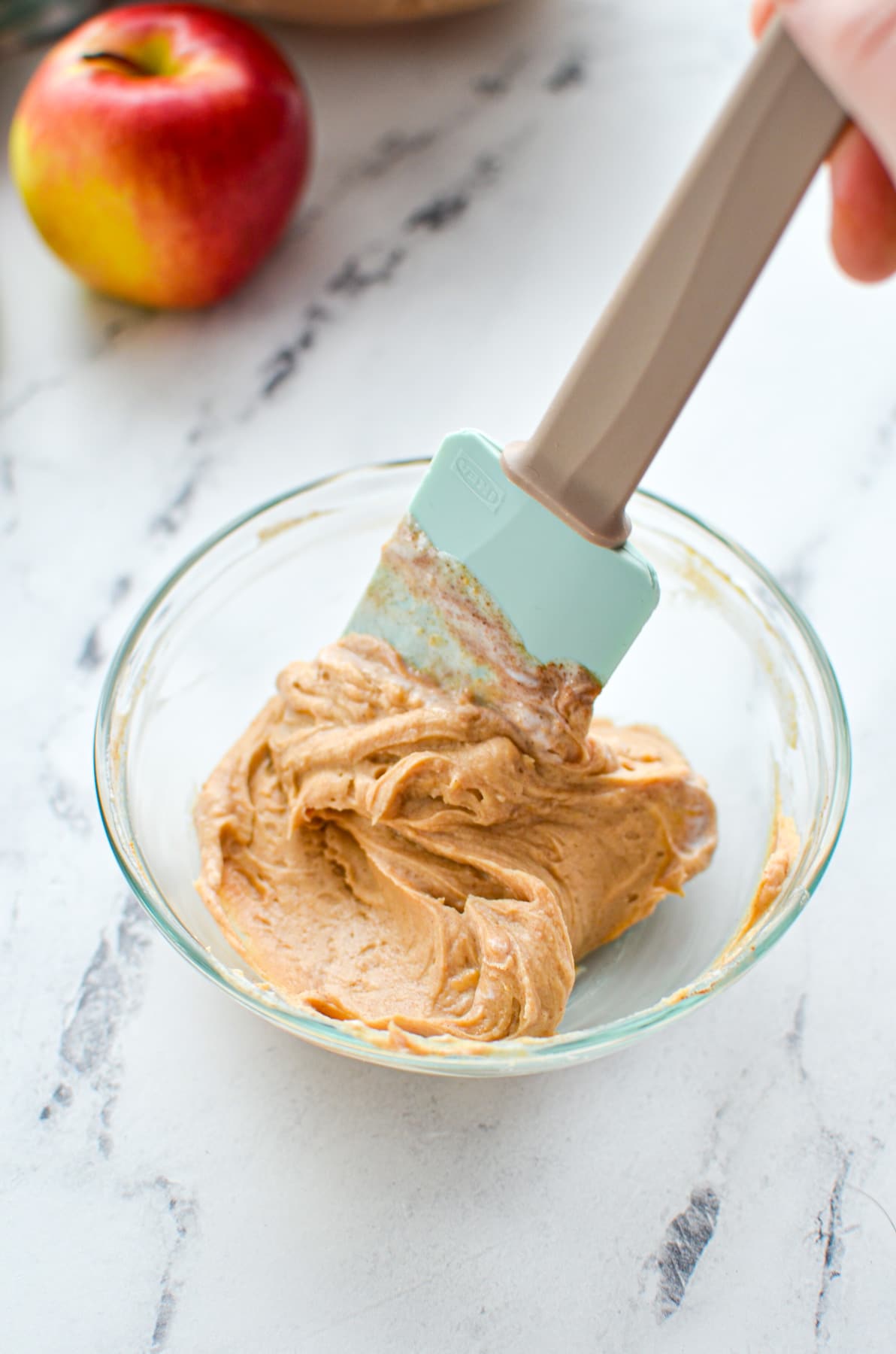 A smooth peanut butter dip inside of a small bowl. 