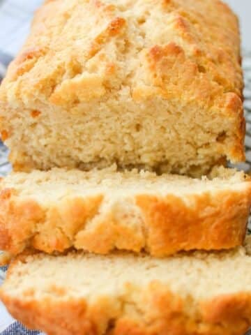 A loaf of quick bread on a wire rack, sliced into thick slices.