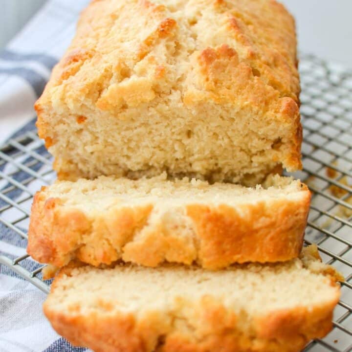 A loaf of quick bread on a wire rack, sliced into thick slices.