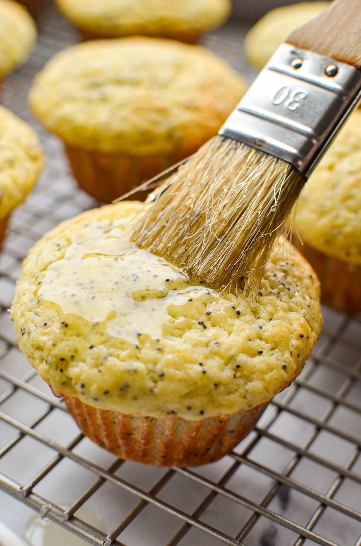 Brushing a glaze onto a lemon poppyseed muffin.