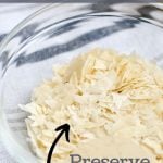A small bowl of sourdough flakes, with a text overlay that reads: how to dry starter: preserving your sourdough starter.