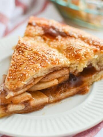 A slice of apple pie on a white plate.