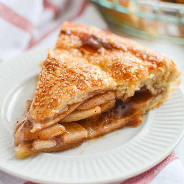 A slice of apple pie on a white plate.