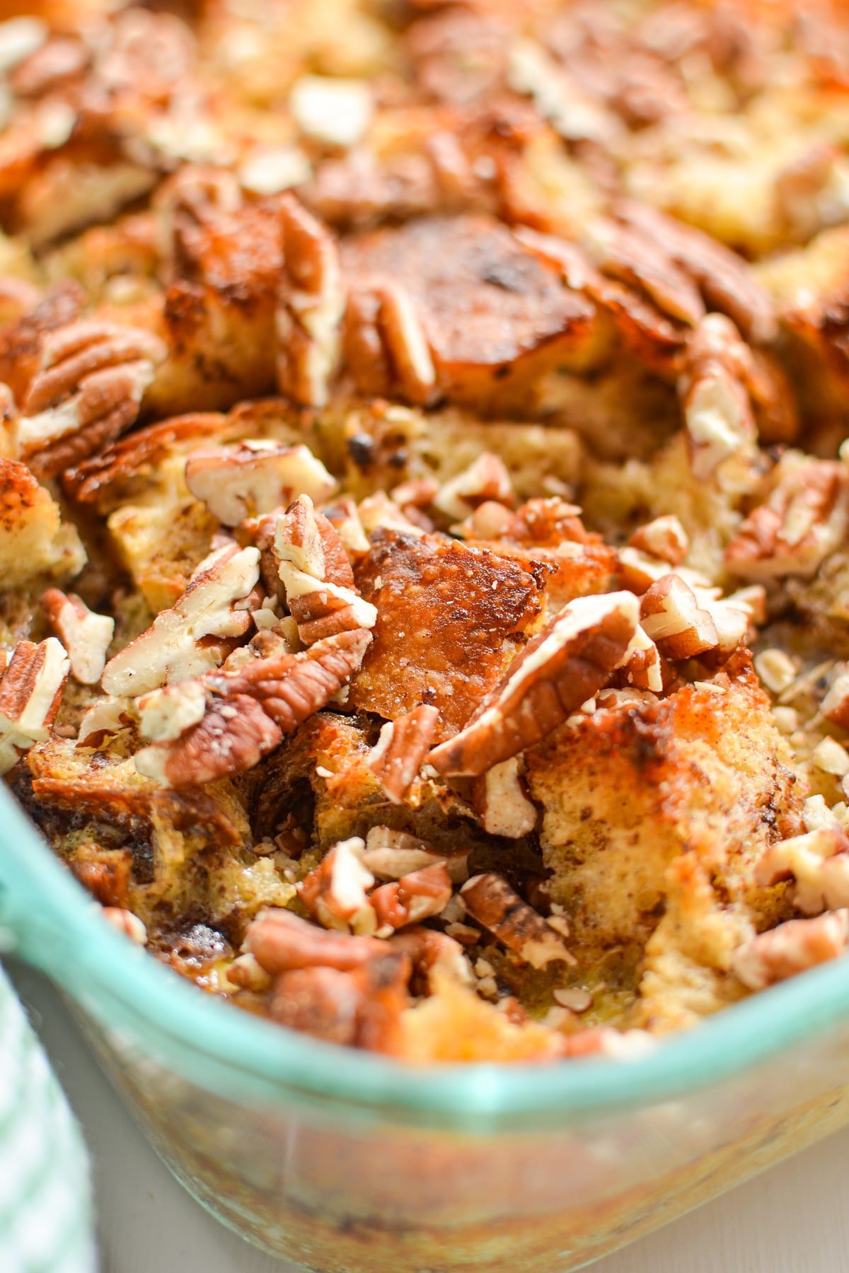 A close up of bread pudding, dotted with pecans.