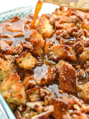 A close up of a pan of sourdough bread pudding, being topped with a brown sugar topping.