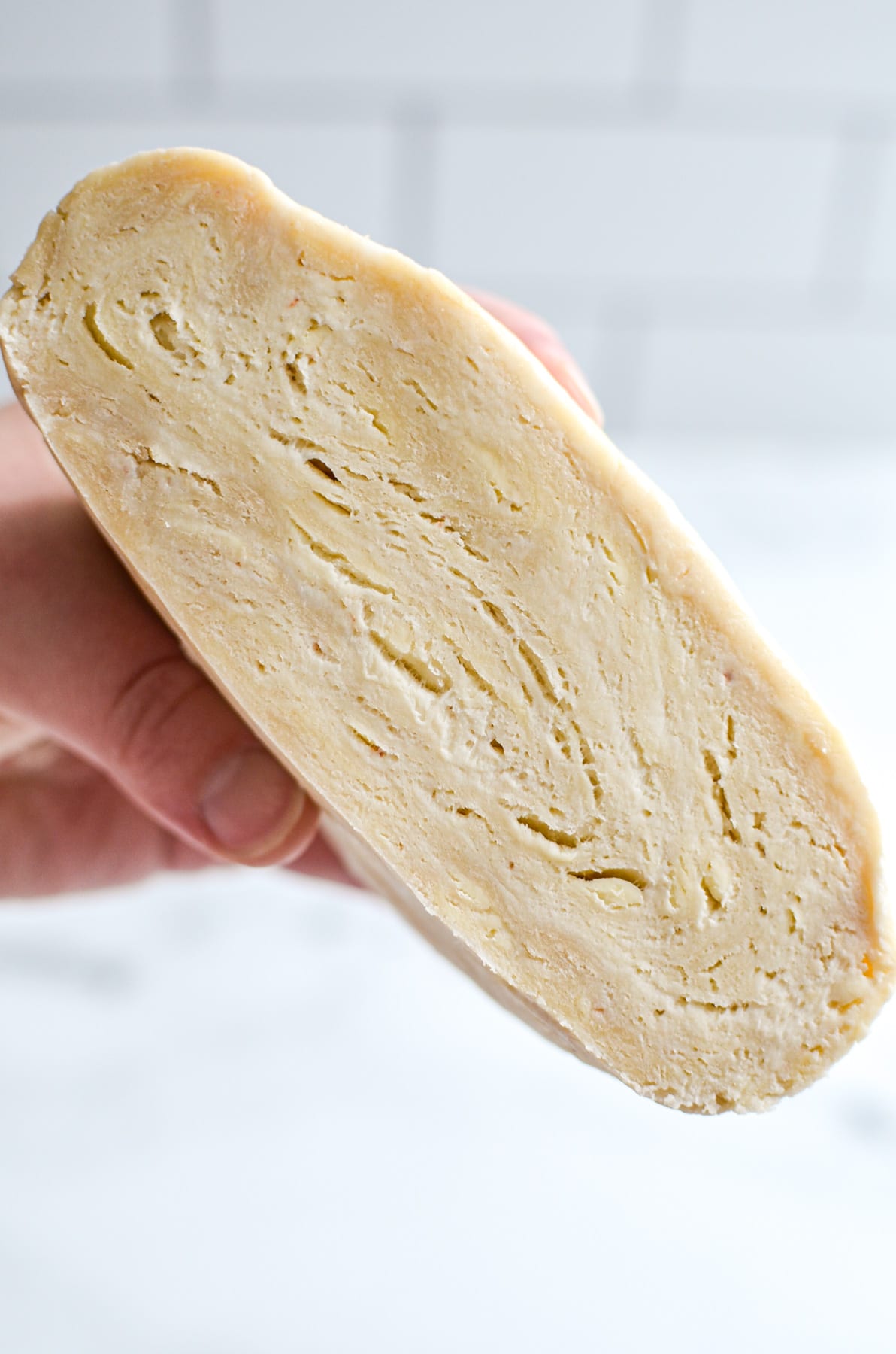 A chunk of pie dough, cut in half to expose the flaky layers.