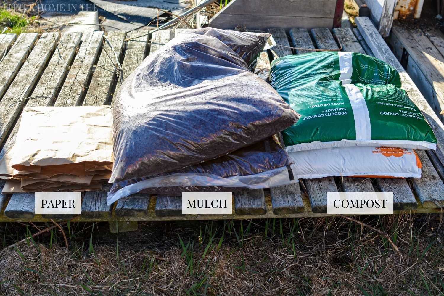 The materials needed to prepare a raised bed: paper, mulch, and compost.