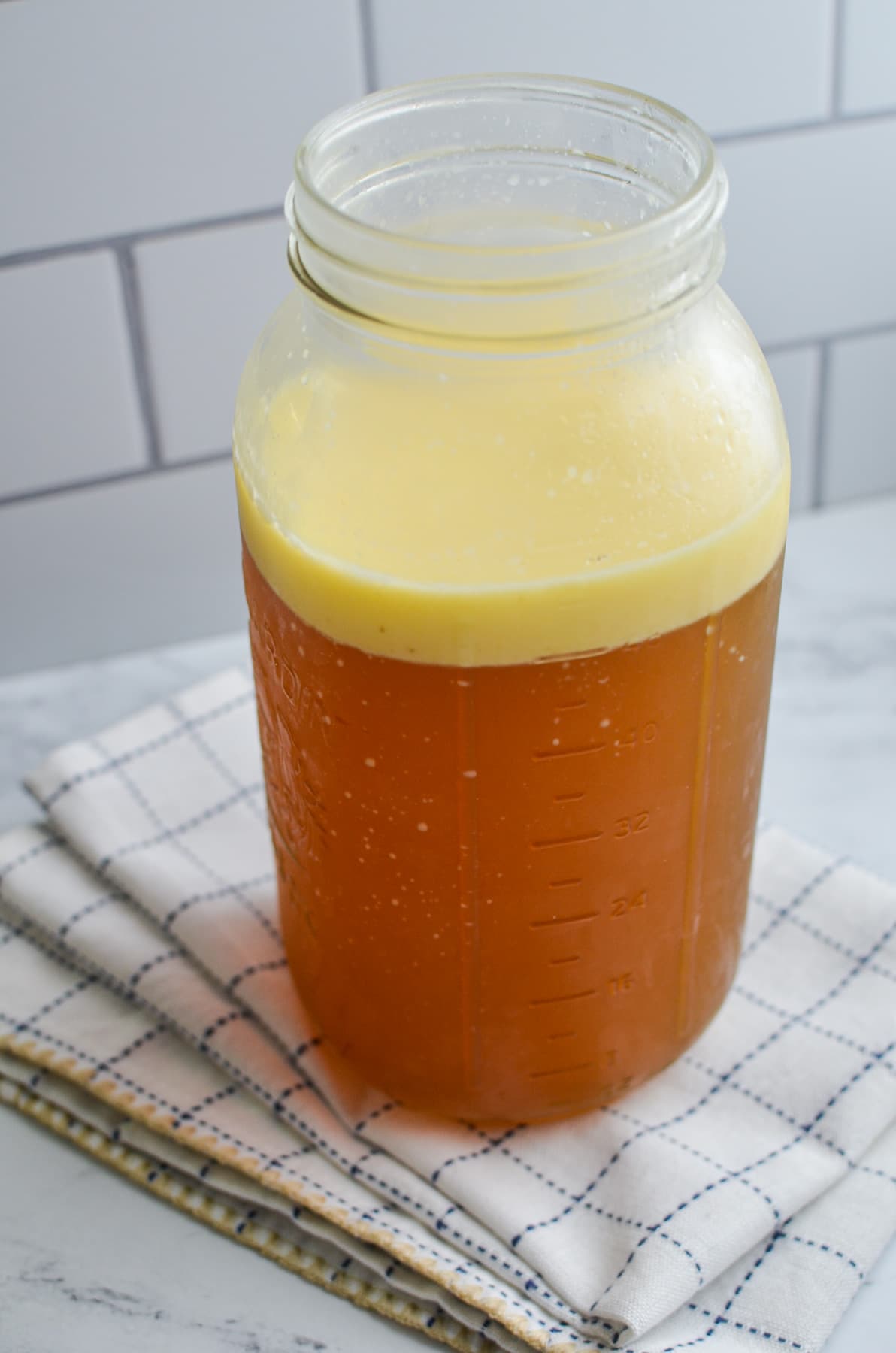 A large jar of bone broth with a fat layer.
