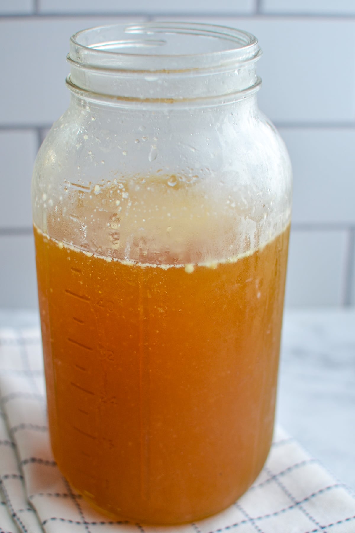 A jar of bone broth resting on a napkin.