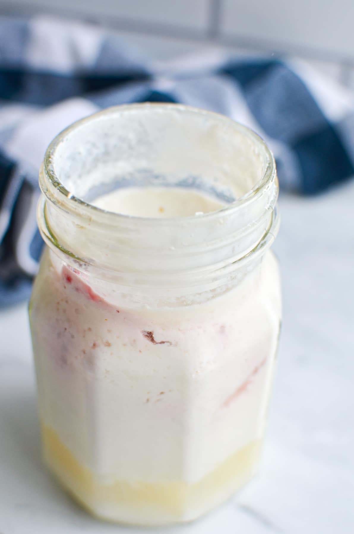 A jar of milk kefir that has separated into whey and kefir.