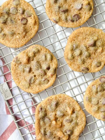 A cooling rack with chocolate chip cookies on it.