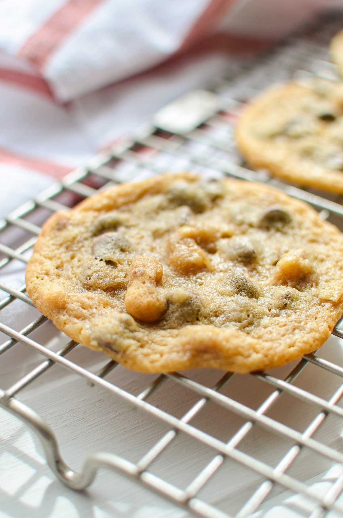 A close up of a cookie on a wire cooling rack.