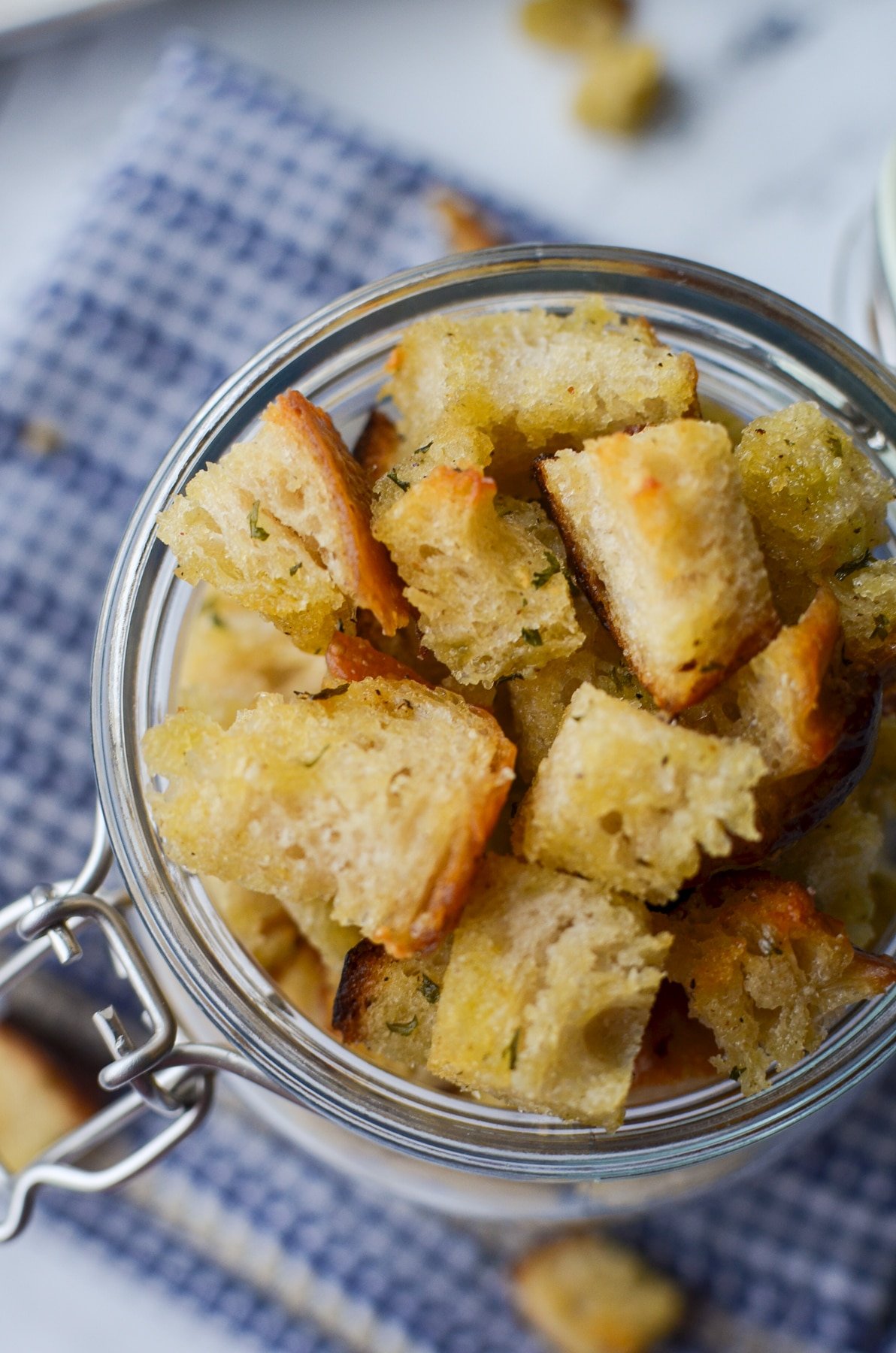 An overhead shot of a jar of homemade sourdough croutons.