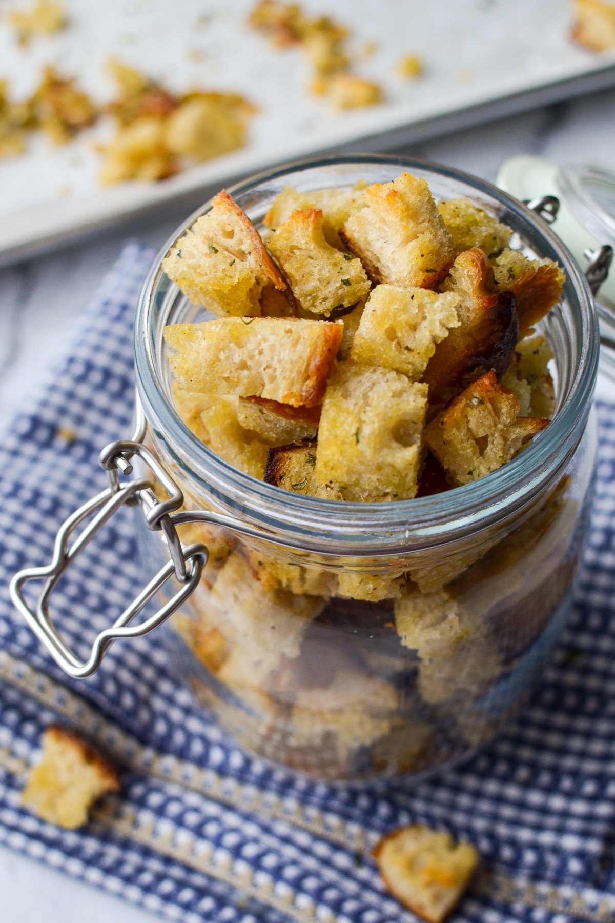 A jar of sourdough croutons, resting on a cloth napkin.