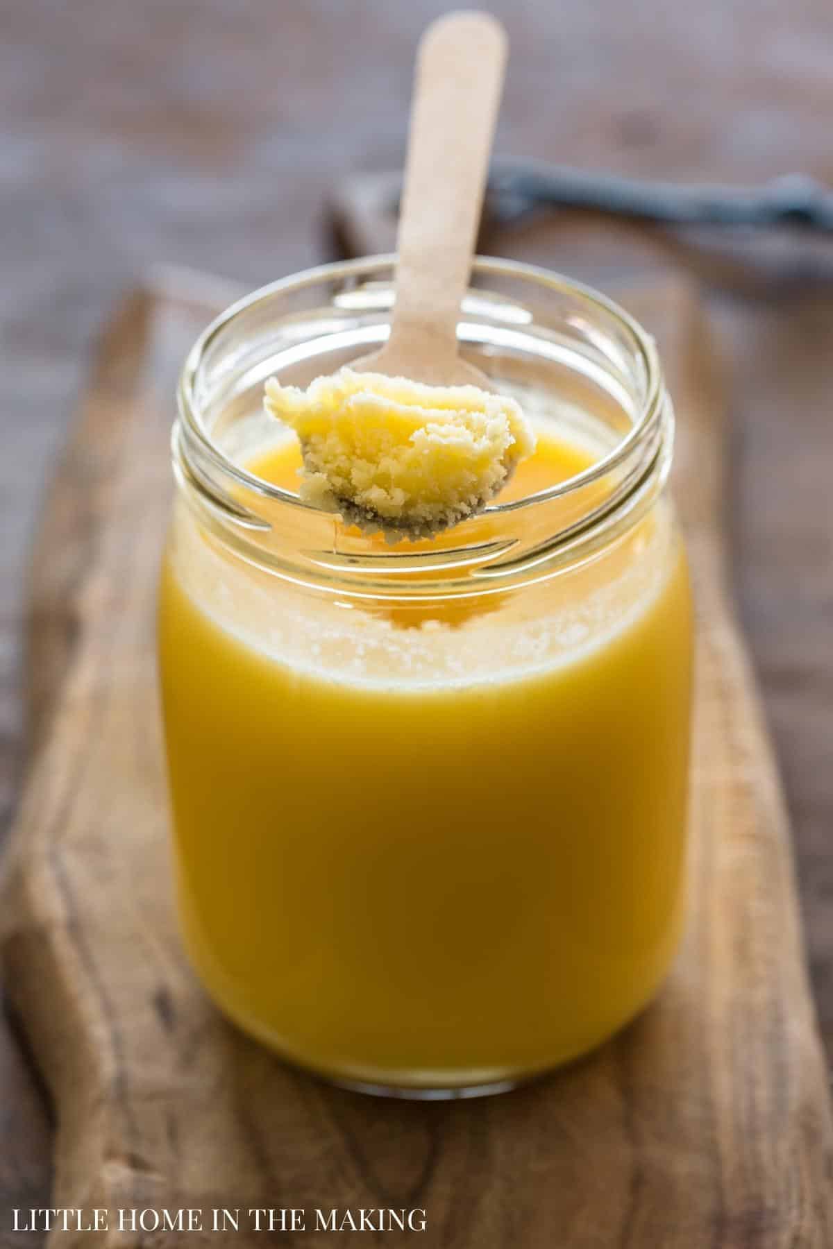 A jar of ghee, with a spoon in it.