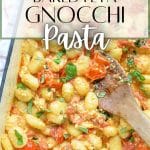 A baking dish with gnocchi, tomato, and basil.