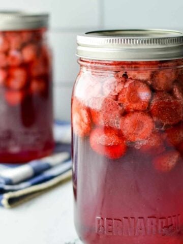 jars of strawberries that have been canned in syrup.