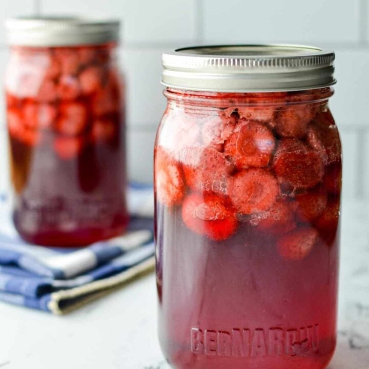 jars of strawberries that have been canned in syrup.